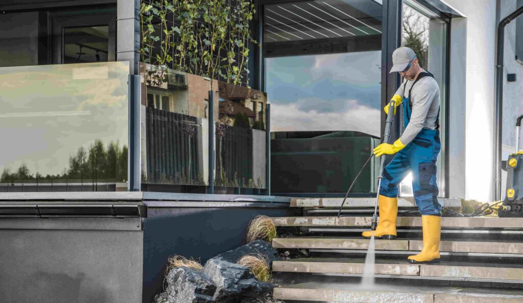 Glas & Fassadenreinigung caucasian homeowner pressure washing his garden paths